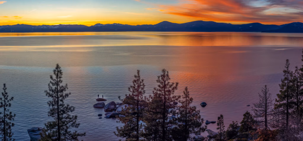 Sunset over Lake Tahoe with Sierra Nevada mountains reflected in the water