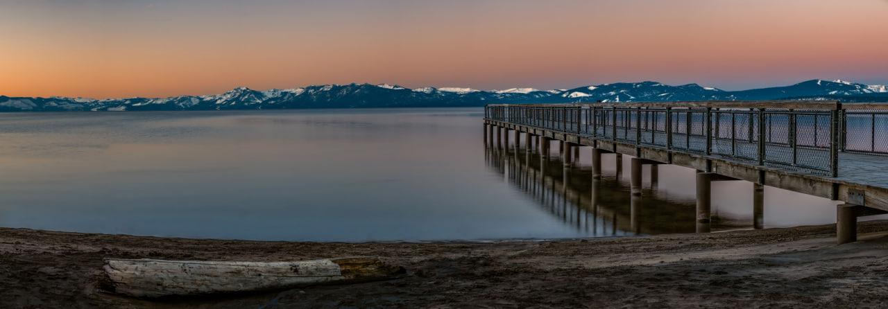 Lake Tahoe with open water and Sierra Nevada mountains beneath an expansive sky.